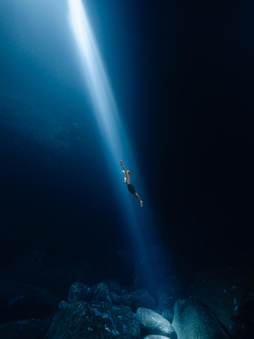 Freediving in a underwater cave with the firsts sunbeams.