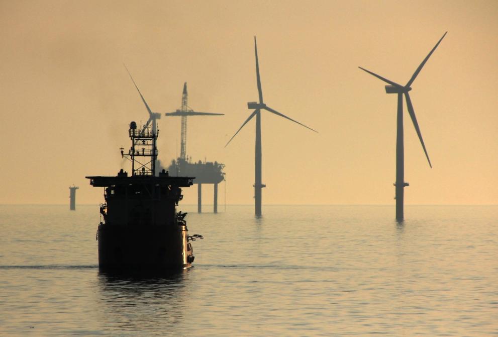 A construction vessel working at Gwynt-Y-Mor windfarm, as a turbine nears completion in the background.